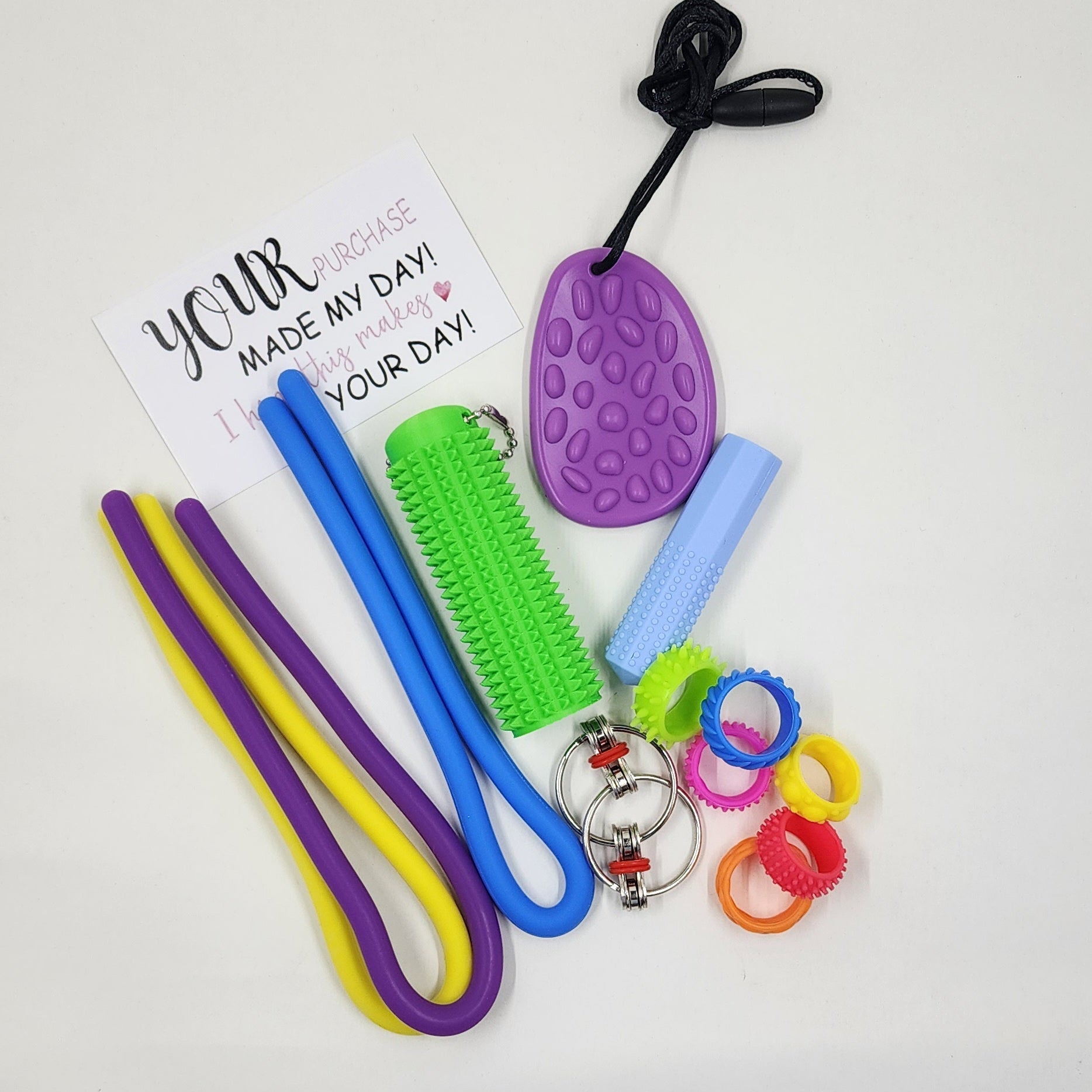 Colorful sensory tools including sticks, a ball, and keychains on a white background with a card.